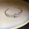 Macro detail of elegant pink zircon butterfly and pearl inlay on a double open bangle - Silver Pink