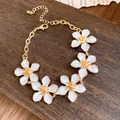 Bracciale retrò dorato con cinque delicati fiori in smalto bianco e catena regolabile - Bianco