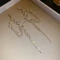 Detailed view of long tassel earrings with sparkling iridescent rhinestones and star motifs. - Silver Post Long Tassel Earrings / Gold-Rainbow