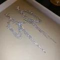 Close-up of elegant silver needle earrings with rhinestone flowers and long tassels - Silver Post Long Tassel Earrings / Silver