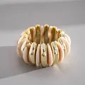 Vista dettagliata dei segmenti in acrilico marmorizzato e metallo dorato sul bracciale vintage. - Oro