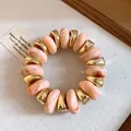 Detailed view of marbled pink beads and gold spacers on a vintage style bracelet - Pink