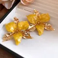 Detailed view of vintage yellow enamel flower earrings with golden metallic petals - Earrings (Silver Earring Post) / Yellow