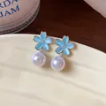 Close-up of elegant flower earrings with light blue petals and dangling white pearls - Cherry Blossom Style (Blue) / Silver
