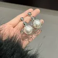 Close-up of elegant silver-colored metal chain earrings with large white pearls - Entwined Dream Tassel Style (HE33724) / Silver-White