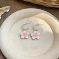 Primo piano di ciondoli a fiore in smalto rosa e bianco su orecchini a cerchio a forma di C - Bottone Fiore a C (Argento) / Confezione da 1 paio / Rosa
