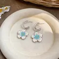 Dettaglio di orecchini a cerchio a forma di C con fiori smaltati bianchi e blu. - Bottone Fiore a C (Argento) / Confezione da 1 paio / Blu