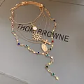 Close-up detail of a gold multi-layer necklace featuring cross sun and Virgin Mary charms - Gold