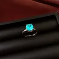 Detailed view of an elegant cushion-cut aqua zircon ring set in a premium black display - Adjustable Ring / Light Blue