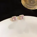 Detailed close-up showing pink square cubic zirconia stud earrings in a luxury gold setting - Gold Brown