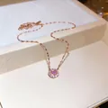 Detailed view of an elegant rose gold necklace with a sparkling pink zircon halo pendant. - Rose Gold-Pink