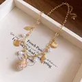 Dettaglio ravvicinato di una collana di perle dorate con ciondolo di conchiglia naturale - Oro