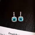 Elegant silver-tone halo earrings with square light blue gemstone and shimmering CZ accents. - Blue Square Drop (49#)