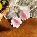 Detailansicht von zwei eleganten rosa Stoffblumen-Haarspangen auf rustikalem Holzgrund - Entenschnabel-Clips / 1 Stück / Weiß, Grün