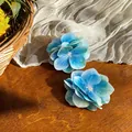 Detailansicht der blauen Hortensien-Haarspangen aus Stoff auf Holzgrund - Entenschnabel-Clips / 1 Stück / Blau