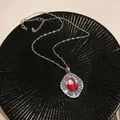 Macro view of vintage court style zircon necklace with sparkling red oval stone - Oval Gradient Halo Style (HN11764)