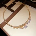 Dettaglio del girocollo dorato con cristalli di zircone a goccia in una scatola di lusso - Stile con Nappa Corta / Oro