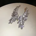 Close-up detail of sparkling leaf-shaped earrings with premium marquise-cut rhinestones - Silver-Clear
