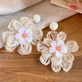 Detailed view of woven raffia flower earrings with delicate pink fabric centers. - Flower Style (HE34251) / White And Pink