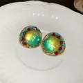 Elegant vintage iridescent green stud earrings with colorful stone accents on a white plate - Silver Earring Post Style / Gold-Blue