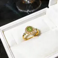 Dettaglio che mostra il design del fiore in zircone verde su un elegante anello d'oro - Oro Verde
