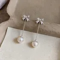 Detail shot of bowknot zircon stud earrings with elegant pearl tassel drops. - Bow Tassel / Pink