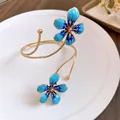 Macro detail of the elegant blue enamel flower petals on the gold-tone metal armlet - Blue