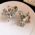 Detailed close-up of silver-toned metal flower rings with hammered petal textures. - Ring and Bracelet 2-Piece Set / Silver