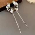 Close-up detail showing the metallic texture of silver flower tassel drop earrings - Silver