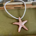Vue détaillée d'un grand pendentif étoile de mer pêche sur un collier en cordelette blanche - Collier Seul (Sans Boucles d'Oreilles) / Rose