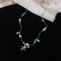 Detail einer Perlenkette mit Zirkonia-Seestern auf elegantem schwarzem Hintergrund. - Blau Perlen Seestern Stil / Silber