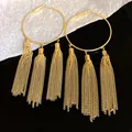 Close-up detail view of gold hoop earrings featuring elegant long chain tassels design - Tops / Gold