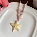 Detailed view of the ceramic starfish pendant on a pink and white beaded rope necklace - Pink-White