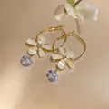 Detail shot of elegant gold hoop earrings featuring white resin flower and purple zircon drop - French Minimalist Hoop (HE32185) / Gold-White