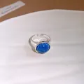 Gros plan d'une bague réglable en argent avec un détail de pierre bleue ronde - Pierre Bleue Ronde (HR3658)
