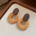 Détail macro de boucles d'oreilles en rotin tressé à la main avec goujons en bois - Style Tige d'Oreille en Argent / Marron