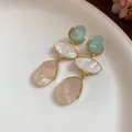 Gros plan sur des boucles d'oreilles en résine vintage aux tons vert, blanc et pêche - Pendentif Goutte d'Eau Style Palais Vintage / Bleu