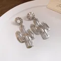 Detailaufnahme von silbernen Kaktus-Ohrhängern mit gehämmerter Metallstruktur - Silber