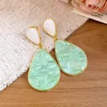 Macro detail of vintage-style mint green resin teardrop shaped dangle earrings - Green