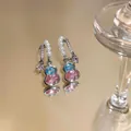 Elegante kürbisförmige Ohrringe mit Perlen und bunten Zirkonsteinen auf Spiegel. - Silber-Blau-Rosa