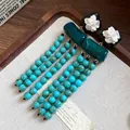 Detailansicht von Retro-Resin-Blumenohrringen mit marmorierten türkisfarbenen Perlen. - Silberner Ohrstecker-Grün