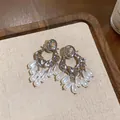 Detailed view of silver statement earrings with crystal studs and teardrop pearl fringes. - Oval Pearl Tassel Style / Silver (Silver Pin)