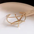 Macro view of a gold-toned starfish open cuff bracelet with textured metallic finish - Starfish Style (HB5926) / Gold