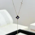 Nahaufnahme einer goldenen Halskette mit blauem Stern-Anhänger im schicken Vintage-Stil - Nordstern Rhombus Anhänger / Hellkaffeegold