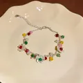 Elegante bracciale di perline colorate con ciondoli a fiore bianco su un piatto di ceramica - Bracciale Bianco Multicolore