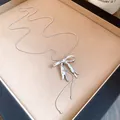 Detailansicht einer silbernen Metallkette mit Falten-Schleifenanhänger und Schlangenkette - Halskette - Silber