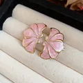 Close-up of pink enamel flower earrings with gold-tone edges in jewelry box - Pink