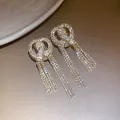 Detailed view of sparkling full rhinestone bow earrings with elegant long tassels. - Bowknot Tassel Studs / Gold
