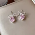 Dettaglio di orecchini a lobo con fiocco d'argento e fiori di zircone rosa brillanti. - Perno per orecchini in argento - Argento - Rosa