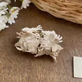 Detailed macro view of off-white leather flower stud earrings with central pearl beads. - Flower Stud Earrings / Gold with White